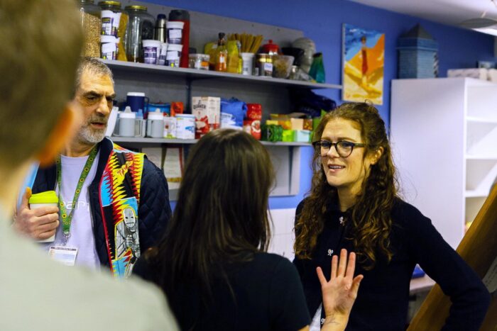 Keeley Howarth chatting with others inside Headway East London's space